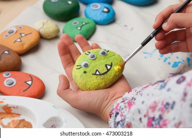 Child Painting A Stone Monster Craft