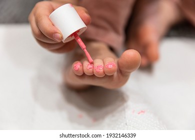 Child painting toenails in pink at home pedicure. Shallow depth of field.  - Powered by Shutterstock