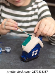 Child Paints A Papier-mâché House