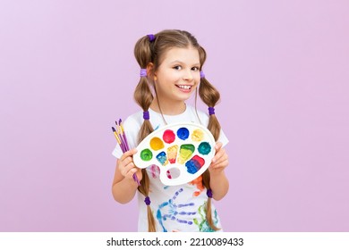 A child with paints on an isolated background, a little girl is fond of painting. - Powered by Shutterstock