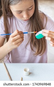 A Child Paints A Wooden Blank Of A Nesting Doll. Children's Crafts