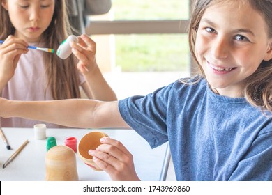 A Child Paints A Wooden Blank Of A Nesting Doll. Children's Crafts