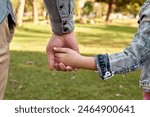 Child, parent and holding hands in nature or back, childhood development and growth with love for girl. Parenting, walking and park for relationship on vacation, people bonding and caring father