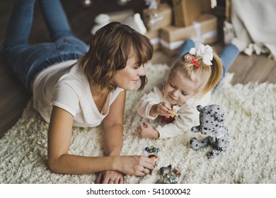 Child And Parent Play With Toys On The Floor.