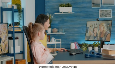 Child And Parent Talking To Adult And Girl On Video Call At Desk. Mother And Daughter Feeling Cheerful, Bonding With Friends On Online Conference For Remote Chatting On Internet Connection.