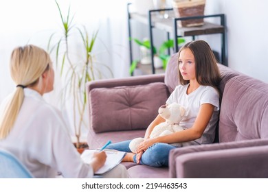 Child Patient Talks To Psychologist, Hugging Teddy Bear, At Home, In Office, Expressing Emotions. Sad Pre-teen Girl Listens To Psychologist At Meeting, Thinking About Her Problems. Successful Therapy.