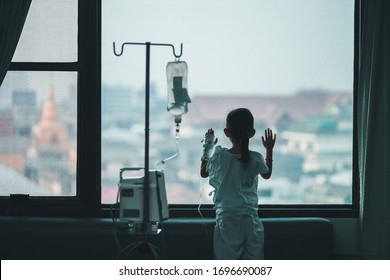 Child Patients In The Hospital Are Adding Saline Solution On Hand , Stand At The Window To Look Out.