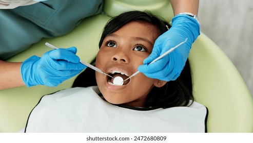 Child, pediatric dentist and checkup of teeth in chair and family friendly examination for tooth health. Girl, dental mirror and consultation by orthodontist with trust and examination for mouth care - Powered by Shutterstock