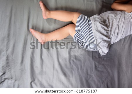 Child pee on a mattress,Little girl feet and pee in bed sheet,Child development concept ,selected focus