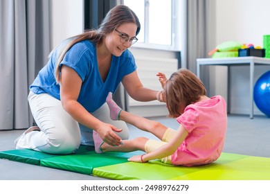 Child with physical disability in physical therapy session. Child living with cerebral palsy exercising with her therapist during physiotherapy. - Powered by Shutterstock