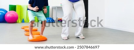 Child and physical therapist during session. Child exercising in physio therapy. Bilateral coordination or integration is the ability to use both sides of the body together in a coordinated way.