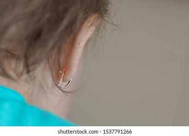 The Child With The Pierced Ears Is Younger Than Three Years