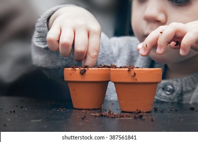 Child Planting Seeds In Pots