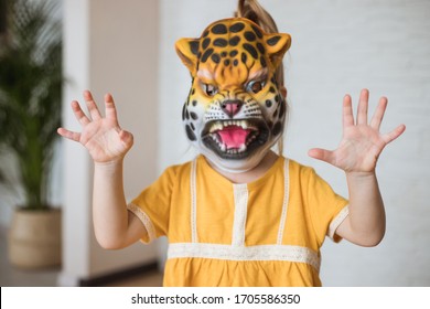 Child Play At Home In Animal Role. Little Girl Wearing A Tiger Mask.