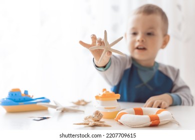 Child Play With Sea Shells And Boats. Summer Vacation And Travel Concept. Kid Play With Lifebuoy And Starfish.