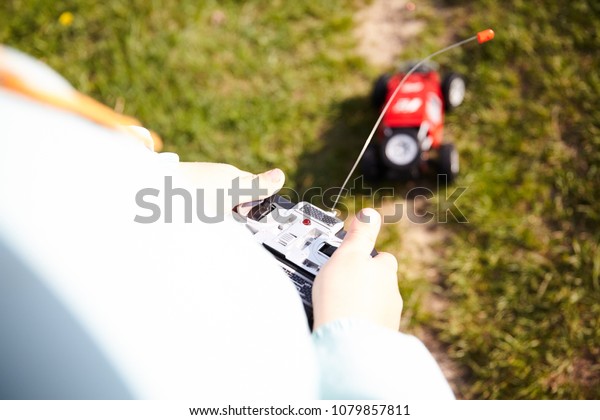 Child played red\
rc car outdoor on green\
grass