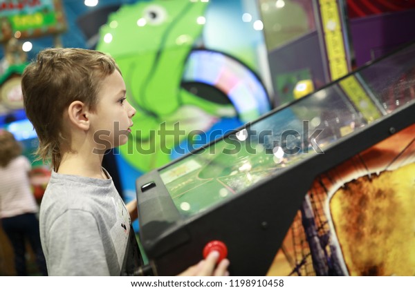 Child playing\
arcade game in redemption\
center