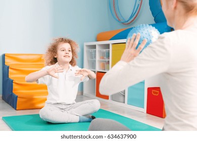 Child Playing Ball With Physiotherapist During Sensory Integration Session