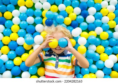 Child Playing In Ball Pit. Colorful Toys For Kids. Kindergarten Or Preschool Play Room. Toddler Kid At Day Care Indoor Playground. Balls Pool For Children. Birthday Party For Active Preschooler.