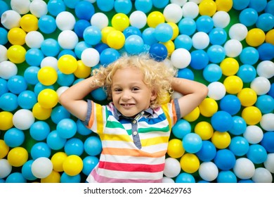 Child Playing In Ball Pit. Colorful Toys For Kids. Kindergarten Or Preschool Play Room. Toddler Kid At Day Care Indoor Playground. Balls Pool For Children. Birthday Party For Active Preschooler.