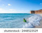 Child playing in the beach surf outside Fort Jefferson on Dry Tortugas National Park.