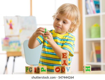 Child Playing With Block Toys And Learning Letters