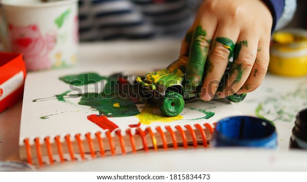 A child playing with\
car and paints