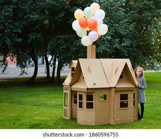 Child Playing In A Cardboard Playhouse. Eco Concept