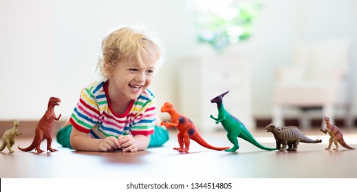 Child Playing With Colorful Toy Dinosaurs. Educational Toys For Kids. Little Boy Learning Fossils And Reptiles. Children Play With Dinosaur Toys. Evolution And Paleontology Game For Young Kid.