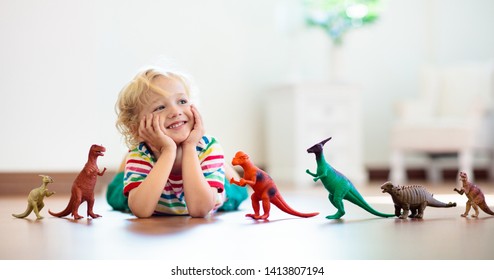 Child playing with colorful toy dinosaurs. Educational toys for kids. Little boy learning fossils and reptiles. Children play with dinosaur toys. Evolution and paleontology game for young kid. - Shutterstock ID 1413807194