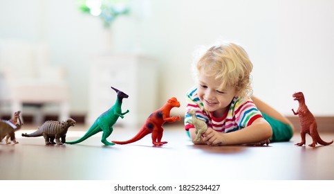 Child Playing With Colorful Toy Dinosaurs. Educational Toys For Kids. Little Boy Learning Fossils And Reptiles. Children Play With Dinosaur Toys. Evolution And Paleontology Game For Young Kid.