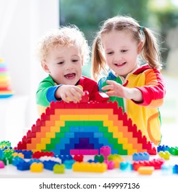 Child Playing With Colorful Toys. Little Girl And Funny Curly Baby Boy With Educational Toy Blocks. Children Play At Day Care Or Preschool. Mess In Kids Room. Toddlers Build A Tower In Kindergarten.
