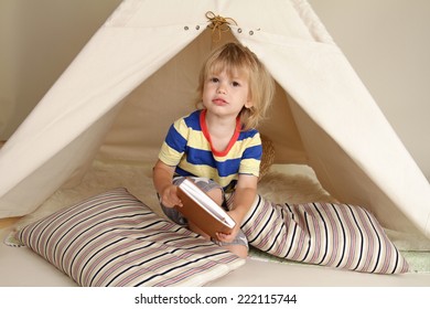 Child Playing At Home Indoors With A Teepee Tent