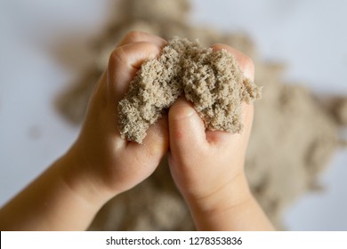 Child playing with kinetic sand. Baby's sensory experiences
