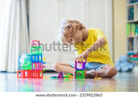 Child playing with magnetic building blocks. Little boy building tower. Educational toys for kids. Construction toys for young children. Geometry and math game. Preschool fun.
