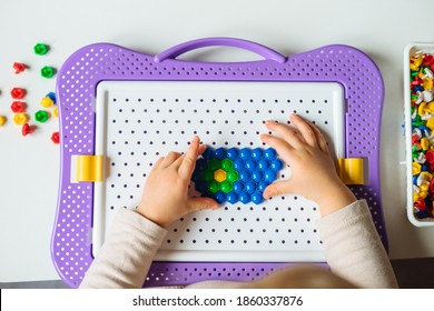 Child is playing with mosaic puzzle at home. Children's creative game for early development and fine motor skills. - Shutterstock ID 1860337876