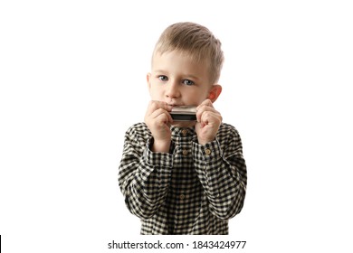 
The Child Is Playing Music. The Boy Is The First To Try To Play The Harmonica. Studio Shooting On A White Background.