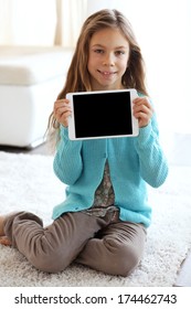 Child Playing On Ipad On A Carpet At Home