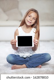 Child Playing On Ipad Sitting On A Carpet At Home