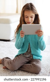 Child Playing On Ipad Tablet Pc Sitting On A Carpet At Home