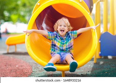 Child playing on outdoor playground. Kids play on school or kindergarten yard. Active kid on colorful slide and swing. Healthy summer activity for children. Little boy climbing outdoors. - Shutterstock ID 1648933216