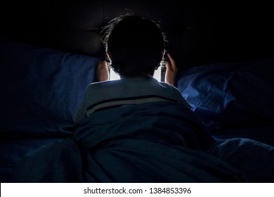 Child playing on a tablet in bed - Shutterstock ID 1384853396