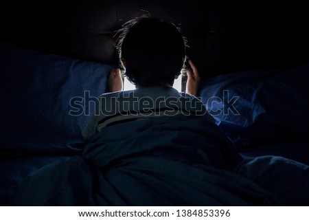 Child playing on a tablet in bed