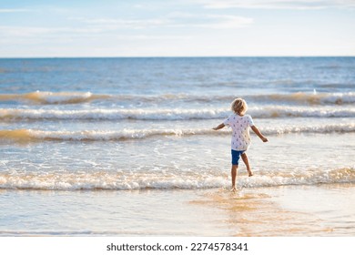Child playing on tropical beach. Little boy with bucket and spade at seashore. Family summer vacation. Kid building sandcastle. Kids search for shells and play. Water and sand fun for children.  - Shutterstock ID 2274578341