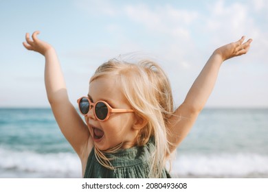 Child playing outdoor emotional surprised emotional funny girl in sunglasses 3 years old toddler raised hands family vacations outdoor