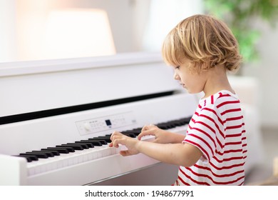 Child Playing Piano. Kids Play Music. Classical Education For Children. Art Lesson. Little Boy At White Digital Keyboard. Instrument For Young Student. Music Class In School Or At Home.