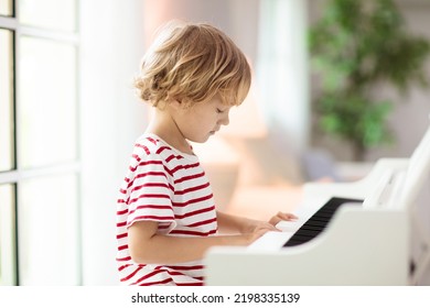 Child Playing Piano. Kids Play Music. Classical Education For Children. Art Lesson. Little Boy At White Digital Keyboard. Instrument For Young Student. Music Class In School Or At Home.