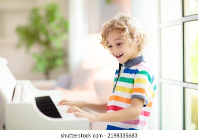 Child Playing Piano. Kids Play Music. Classical Education For Children. Art Lesson. Little Boy At White Digital Keyboard. Instrument For Young Student. Music Class In School Or At Home.