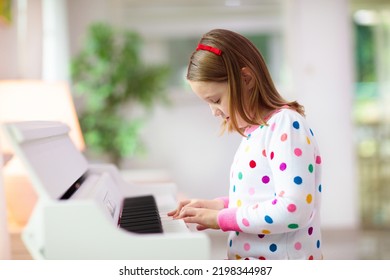 Child Playing Piano. Kids Play Music. Classical Education For Children. Art Lesson. Little Girl At White Digital Keyboard. Instrument For Young Student. Music Class In School Or At Home.