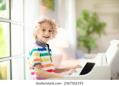 Child playing piano. Kids play music. Classical education for children. Art lesson. Little boy at white digital keyboard. Instrument for young student. Music class in school or at home. - Shutterstock ID 2367362193